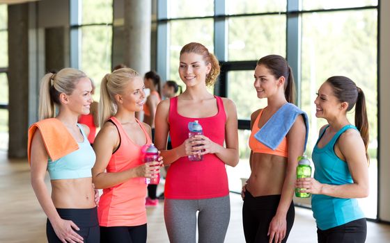 fitness, sport, training, gym and lifestyle concept - group of women with bottles of water in gym