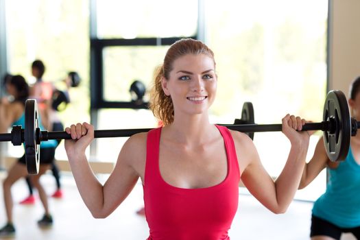 fitness, sport, training and lifestyle concept - group of women with barbells in gym