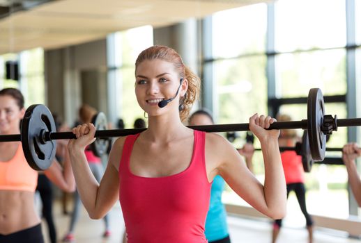 fitness, sport, training, gym and lifestyle concept - group of women with barbells in gym