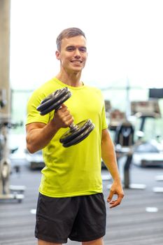 sport, fitness, lifestyle and people concept - smiling man with dumbbell in gym