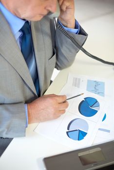 business, people and communication concept - close up of senior businessman with charts and papers calling on telephone