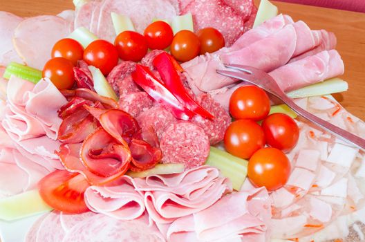 Detail of a big meat delicatessen plate of cold cuts.