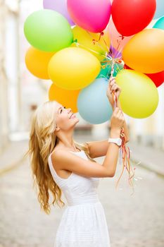 summer holidays, celebration and lifestyle concept - beautiful woman with colorful balloons in the city