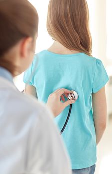 healthcare, medical exam, people, children and medicine concept - close up of girl and doctor with stethoscope listening to heartbeat