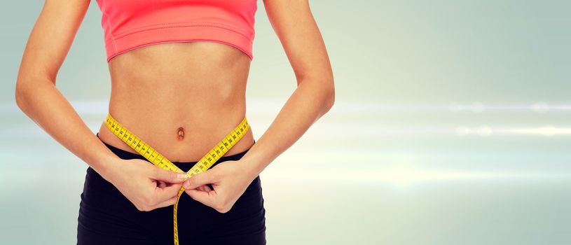 diet, sport, fitness and heath concept - close up of female hands measuring waist with measuring tape