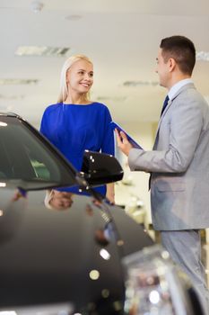 auto business, car sale, consumerism and people concept - happy woman with car dealer in auto show or salon