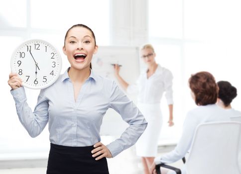 business and time concept - attractive businesswoman with wall clock