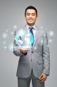 business, people, technology, connection and communication concept - happy businessman in suit showing network contacts and globe hologram over gray background