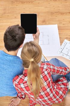 repair, building, renovation, architecture and technology concept - close up of couple with tablet pc computer blank screen and blueprints at home