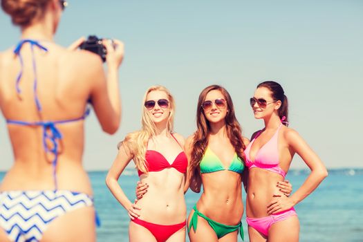 summer vacation, gesture, travel and people concept - group of smiling young women photographing by camera and waving hands on beach