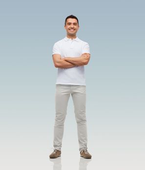happiness and people concept - smiling man with crossed arms over gray background