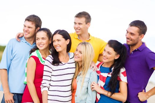 summer holidays, vacation, tourism, travel and people concept - group of happy friends hugging on beach