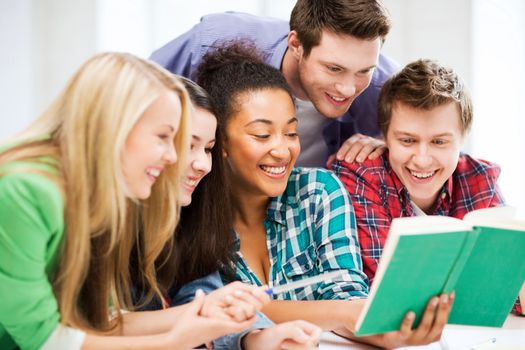 education concept - group of students reading book at school