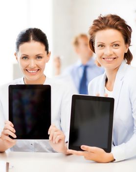 smiling business team showing tablet pcs in office