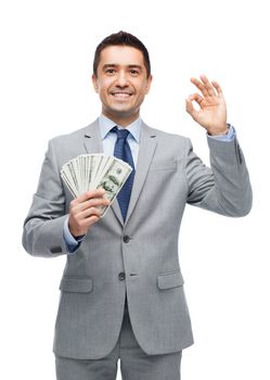 business, people and finances concept - smiling businessman with american dollar money