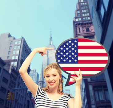education, foreign language, english, people and communication concept - smiling woman holding text bubble of american flag