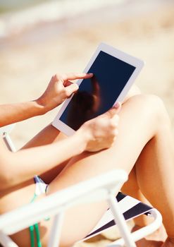 summer holidays, vacation, technology and internet - girl looking at tablet pc on the beach chair