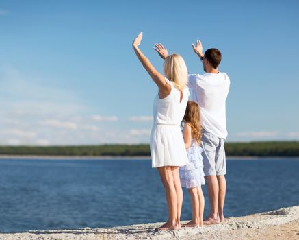 summer holidays, celebration, children and people concept - happy family at the seaside with greeting gesture