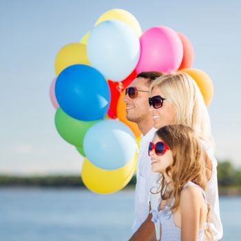 summer holidays, celebration, children and people concept - family with colorful balloons