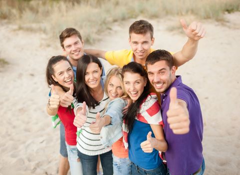 summer holidays, vacation, tourism, travel and people concept - group of happy friends having fun and showing thumbs up on beach
