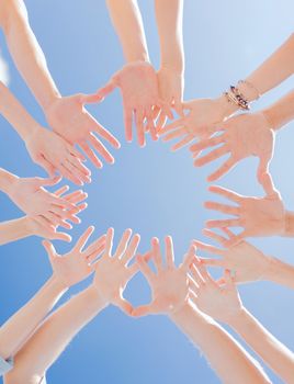 togetherness, team, union, people and gesture concept - close up of many hands over blue sky background