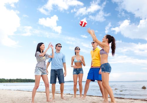 summer holidays, sport, leisure and people concept - group of happy friends playing beach ball