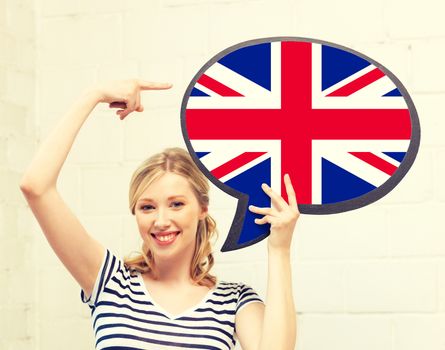 education, foreign language, english, people and communication concept - smiling woman holding text bubble of british flag and pointing finger