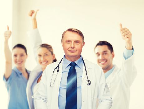 healthcare and medicine concept - smiling standing doctor or professor with stethoscope