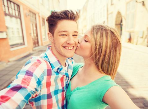 travel, vacation, technology and friendship concept - smiling couple with smartphone in city