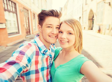 travel, vacation, technology and friendship concept - smiling couple with smartphone in city