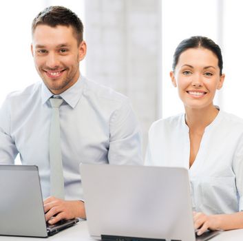 picture of group of people working with laptops in office