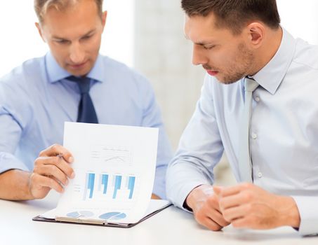 businessmen with notebook discussing graphs on meeting