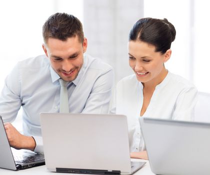 picture of group of people working with laptops in office