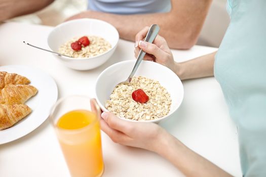 food, eating, people and healthy food concept - close up of couple having breakfast at home