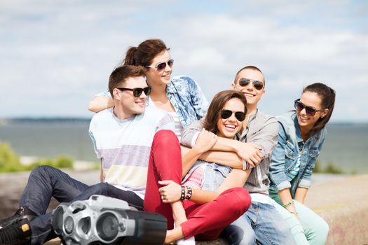 summer holidays and teenage concept - group of teenagers hanging out