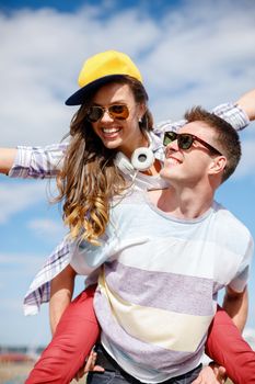 summer holidays, relationships and teenage concept - smiling teenagers in sunglasses having fun outside