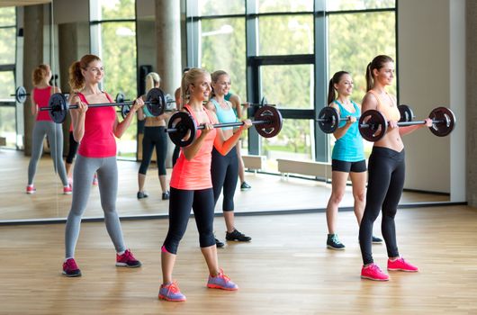 fitness, sport, training and lifestyle concept - group of women with barbells in gym