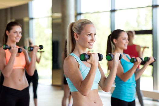 fitness, sport, training, gym and lifestyle concept - group of women with dumbbells in gym