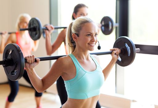 fitness, sport, training and lifestyle concept - group of women with barbells in gym