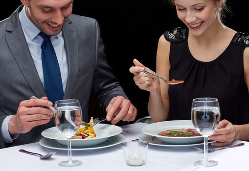 restaurant, food, people, date and holiday concept - close up of happy couple eating at restaurant