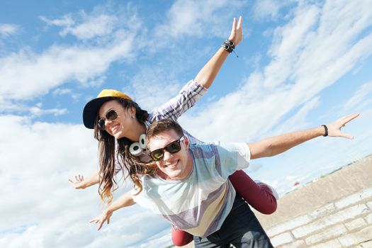 summer holidays and teenage concept - teenagers having fun outside