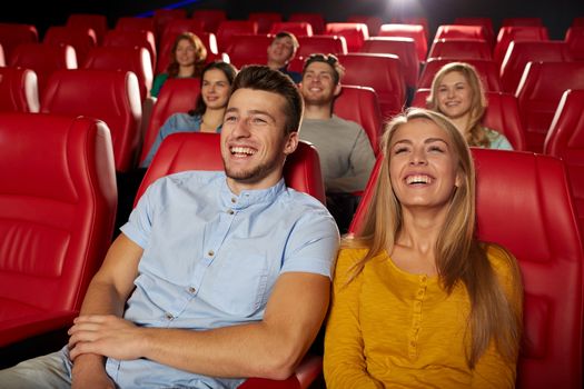 cinema, entertainment and people concept - happy friends watching comedy movie in theater