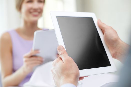 technology, people, food and holiday concept - close up of couple with blank tablet pc computer screen at restaurant