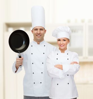 cooking, profession and people concept - happy male chef cook holding frying pan