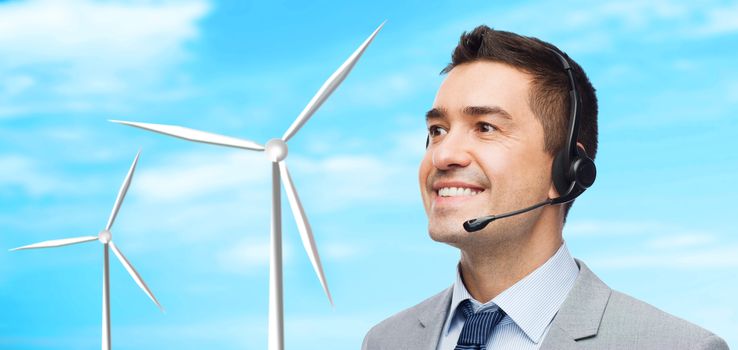 business, people, technology, alternative energy and development concept - smiling businessman in headset