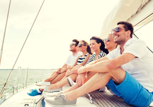 vacation, travel, sea, friendship and people concept - smiling friends sitting on yacht deck