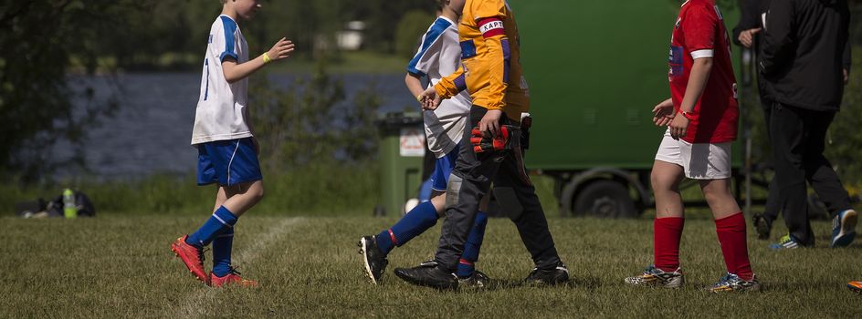 A group of soccer players great each other after the game is over