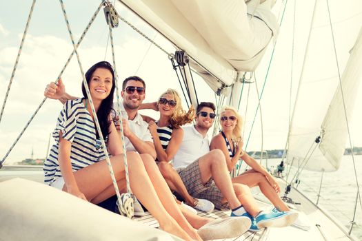 vacation, travel, sea, friendship and people concept - smiling friends sitting on yacht deck