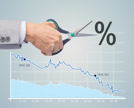 business, people, default, financial and economical crisis concept - close up of businessman hand with scissors cutting percentage sign over chart and gray background