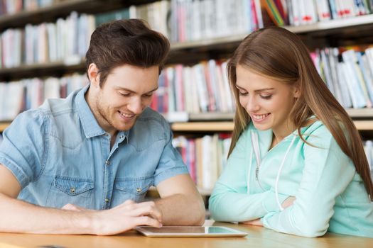 people, education, technology and school concept - happy students with tablet pc computer networking in library